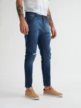 Pantalón de jean azul con roturas en las rodillas, corte skinny y tiro medio.