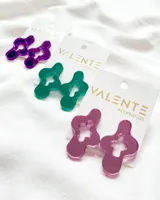 Par de aros colgantes de acrílico color violeta con forma geométrica irregular con aberturas.