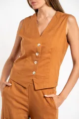 Chaleco de corte sastre con escote en V y cierre frontal de botones. Presenta un diseño sin mangas, entallado al cuerpo, confeccionado en una mezcla de lino y viscosa.