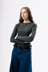 Camiseta de manga larga en color gris oscuro, con cuello redondo y costuras decorativas expuestas en el frente. Presenta un diseño ajustado al cuerpo.