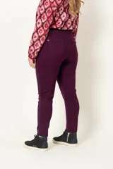 Calza color borgoña con cintura alta, sin cierre, con falsos bolsillos delanteros y bolsillos traseros con detalle de vivo de cuero en bolsillos y laterales.