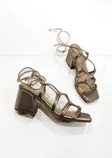 Sandalias de tacón color peltre con tiras finas y cierre con cordones.