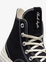 Championes de caña alta Converse Run Star Legacy CX, con diseño de plataforma irregular y voluminosa. Presentan cuerpo de lona negra con costuras blancas a contratono, cordones de algodón y el icónico parche de estrella en el lateral.
