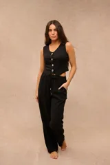 Pantalón largo negro de corte holgado, con cintura elástica ajustable mediante cordón y bolsillos laterales.