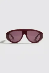 Lentes de sol estilo aviador con armazón grueso color bordó y cristales tonalizados. Cuentan con protección UV400.