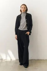 Rompeviento color beige con rayas horizontales finas en marrón, cuello alto y mangas largas.