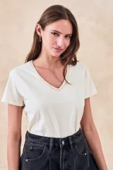 Remera de algodón color mostaza, de manga corta y escote en V con detalle metalizado.