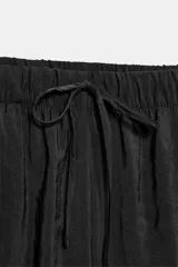 Pantalón fluido confeccionado en mezcla de modal, de tiro medio con cintura elástica ajustable con cordón y bolsillos laterales, en color tostado.