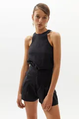 Short de lino negro con cintura alta, pinzas delanteras, bolsillos laterales y cierre frontal con gancho metálico.