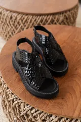 Sandalias de cuero color mostaza con tiras anchas cruzadas y suela track negra.