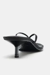 Sandalia de tacón tipo kitten, color negro con acabado satinado. Presenta diseño de dedo tipo ojota y punta redonda.