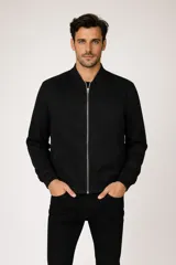 Campera tipo bomber de gamuza sintética en color negro, con cierre frontal metálico, cuello mao y puños y ruedo acanalados.