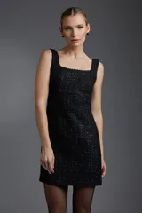 Vestido corto negro de tweed con escote cuadrado y breteles anchos con detalle de puntilla.
