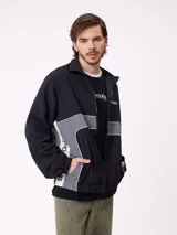 Rompevientos Rusty con cierre frontal, capucha y diseño de bloques de color en gris y verde militar. Cuenta con puños elásticos y logo de la marca en el pecho.