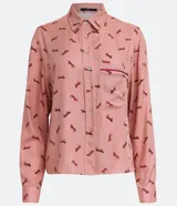 Camisa de viscosa color rosa con estampado de caballos en marrón. Tiene cuello camisero, cierre con botones, mangas largas, un bolsillo frontal y detalle de vivo contrastante en el bolsillo.
