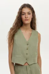 Chaleco sastrero verde militar confeccionado en lino, con escote en V, cierre frontal con botones y bolsillos ojal simulados.