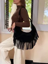 Cartera tipo hobo de cuero negro con diseño de flecos largos en los laterales. Cuenta con una correa de hombro integrada y cierre superior.