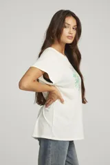 Remera color crema de corte recto y mangas cortas. Estampado vintage con palmeras, sol y la frase "Hawaiian Delight".