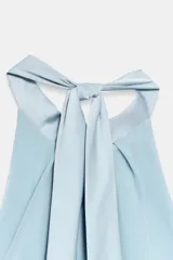 Vestido midi de satén color celeste, con cuello halter y detalle de lazada en la espalda descubierta.