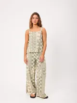 Top de algodón verde y crudo con estampado de motivos marinos, geométricos y tropicales, con tirantes anchos, escote cuadrado y cordones ajustables en los laterales.