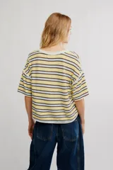 Remera de jersey de algodón con diseño de rayas horizontales en tonos amarillo, celeste y marrón, de calce corto y recto, con escote redondo en contraste, hombros caídos y mangas cortas anchas.
