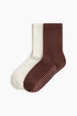 Pack de dos pares de medias de yoga antideslizantes de punto fino con caña acanalada, una en color blanco y otra en color marrón, con puntos de agarre en la suela.