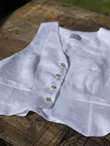 Chaleco de lino en color beige, con escote en V, cierre frontal con botones y bolsillos delanteros decorativos.