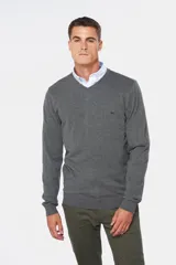 Suéter de tejido fino color azul marino, con cuello en V y manga larga. Presenta un pequeño logo bordado en el pecho.