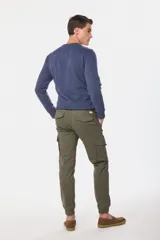 Pantalón cargo azul marino con bolsillos laterales con solapa y cinturón de cuero marrón.