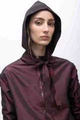 Capucha deportiva color borgoña, confeccionada en tafeta tornasolada. Se ajusta con dos tiras que pueden anudarse formando un lazo.