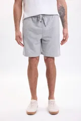 Bermuda de felpa de algodón gris melange con cintura elástica ajustable mediante cordón y bolsillos laterales.