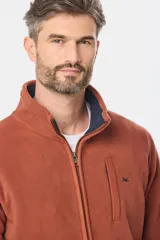 Campera polar térmica de corte recto y cuello alto, con cierre frontal completo en contraste. Presenta bolsillos laterales con cierre y un bolsillo vertical en el pecho, todos con detalles en color azul marino.