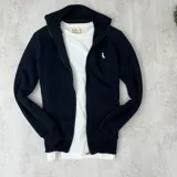 Campera negra con cierre frontal, cuello alto y logo bordado en el pecho.