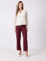 Blusa de encaje color beige, marca Cupio, con cuello a la base y escote en V con lazo de ajuste. Presenta una sobrecapa de encaje con aplique de puntilla y mangas largas de encaje floral translúcido, terminadas en puños elásticos con volado. Incluye forro interno a tono.