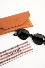 Lentes de sol polarizados con armazón redondo de acetato en color marrón translúcido y micas en tono ámbar.