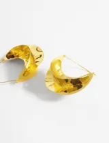 Aros dorados con forma de medialuna y textura irregular.