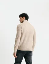 Sweater de punto inglés color verde, con cuello alto y cierre frontal parcial metálico. Diseño de manga larga con puños y ruedo acanalados.