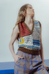 Chaleco tejido a crochet con diseño patchwork multicolor, cuello en V y terminaciones acanaladas en marrón.