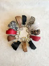 Cinto de cuero color camel con hebilla metálica dorada.