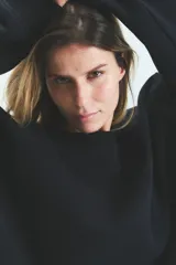 Buzo negro oversize de frisa esmerilada con cuello alto, hombros caídos, bolsillos laterales y estampa en la espalda con el logo de la marca en animal print.