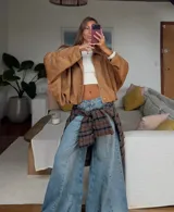 Campera tipo bomber oversized con efecto gamuza, cuello clásico, cierre frontal oculto y hombros estructurados.