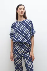 Pantalón acampanado con estampado abstracto en tonos azul marino y beige, con cintura elastizada y cordón ajustable.