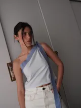 Top celeste y blanco a rayas verticales, con un solo hombro y lazo ancho en color celeste.