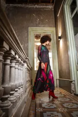 Vestido largo de jersey de licra con estampado abstracto en tonos fucsia, naranja, verde y negro. Diseño sin mangas con escote ojal en la espalda.