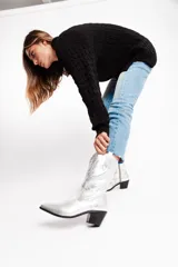 Botas tejanas de cuero plateado con taco bajo y cierre lateral.