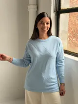 Sweater de punto color celeste con diseño de rombos en relieve en el frente, cuello redondo y mangas largas con puños ajustados.