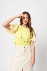 Blusa verde con cuello redondo y mangas cortas abullonadas.