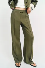 Pantalón recto de tiro bajo en color verde militar, con nervios marcados en la parte delantera, bolsillos frontales y cierre con cremallera, botón interior y ganchos.