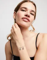 Pulsera plateada con eslabones de bolitas y piezas alargadas.