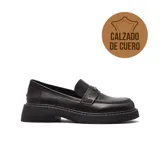 Mocasines de cuero negro con suela track dentada y detalle metálico en el empeine.